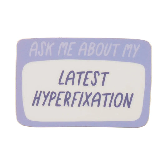 Ask Me About My Latest Hyperfixation die cut waterproof vinyl sticker by And Here We Are x Your Gal Kiwi, approximately 3 inches