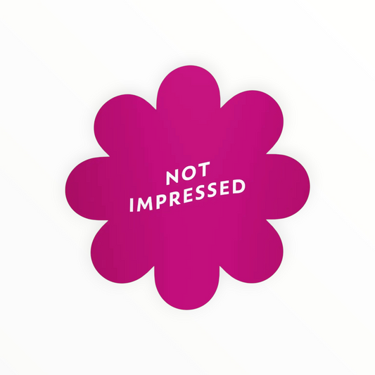 A bright magenta flower-shaped sticker or decal with the words 'NOT IMPRESSED' printed in white inside, shown on a plain white background.