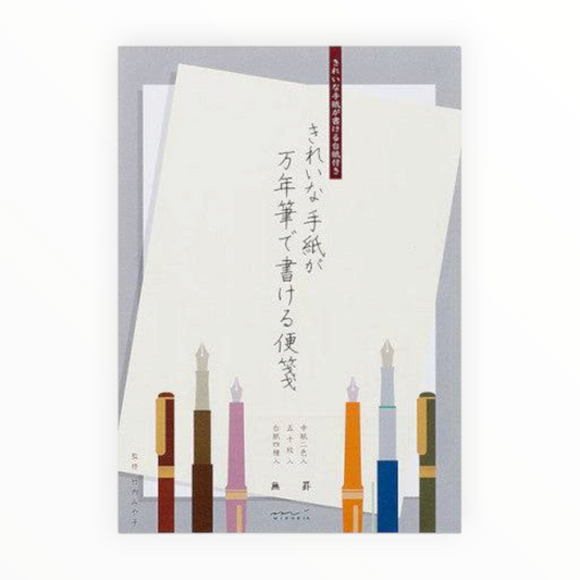 Japanese book cover featuring a cream sheet of paper with vertical black calligraphy and an illustration of six colorful fountain pens at the bottom, set against a light gray background.
