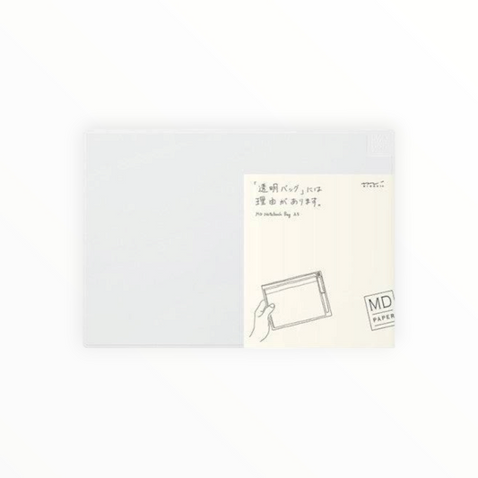 A sheet of translucent white paper partially covering a cream-colored backing card. The backing card features a minimalist illustration of a hand holding a rectangular box and includes Japanese text, the English phrase 'to be carved by age,' and the brand 'MD PAPER'.